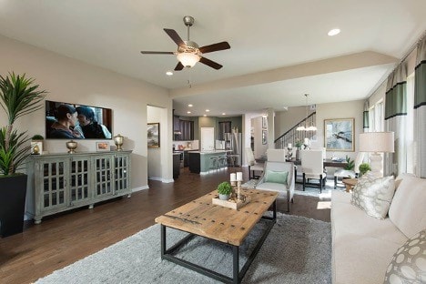 kitchen featuring a center island with sink, sink, dark hardwood / wood-style floors, light stone counters, and stainless steel appliances