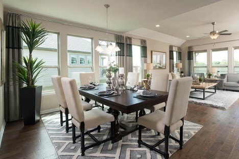 dining area with a wealth of natural light, dark wood-type flooring, and ceiling fan with notable chandelier