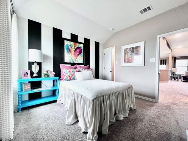 bedroom with carpet floors and lofted ceiling