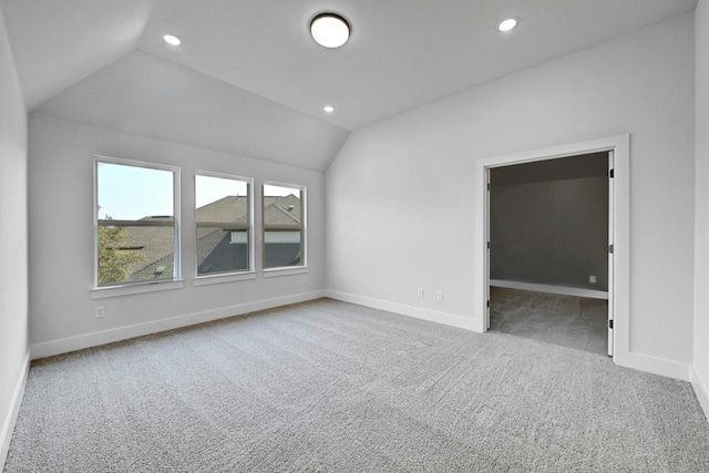 empty room with carpet and vaulted ceiling