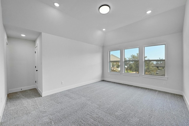 carpeted spare room featuring lofted ceiling