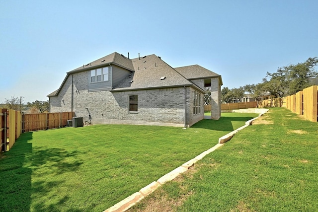 rear view of house with a yard and cooling unit