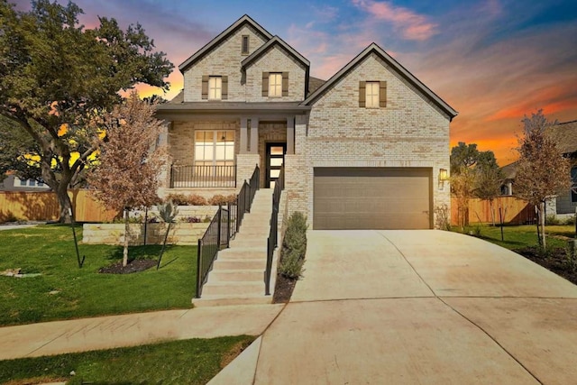 view of front of property with a porch, a garage, and a lawn