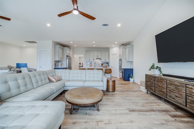 living room with light hardwood / wood-style floors and ceiling fan