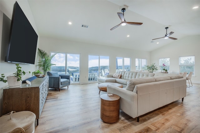 living room featuring light wood-type flooring, a healthy amount of sunlight, lofted ceiling, and ceiling fan