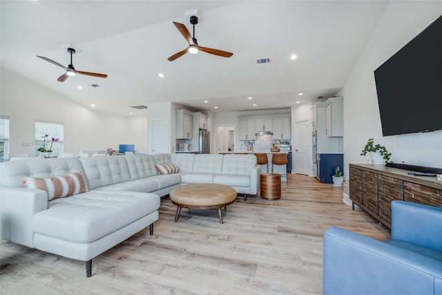 living room with light hardwood / wood-style floors, lofted ceiling, and ceiling fan