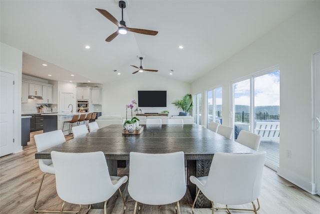 dining room with light hardwood / wood-style flooring, vaulted ceiling, ceiling fan, and sink