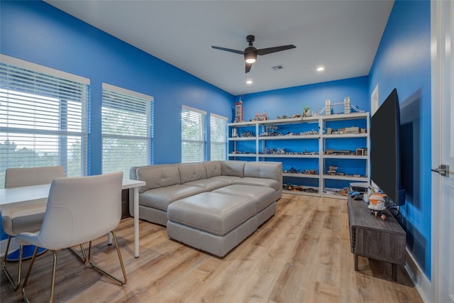 living room featuring light wood-type flooring and ceiling fan