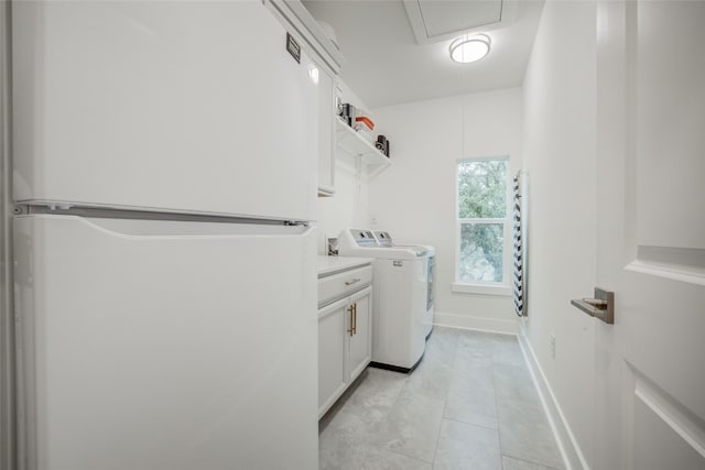 laundry room with cabinets, washing machine and clothes dryer, and light tile patterned flooring