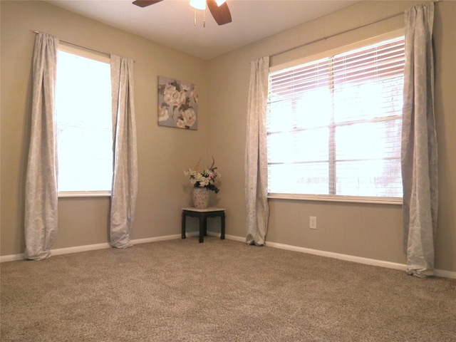 spare room with a wealth of natural light, ceiling fan, and carpet floors