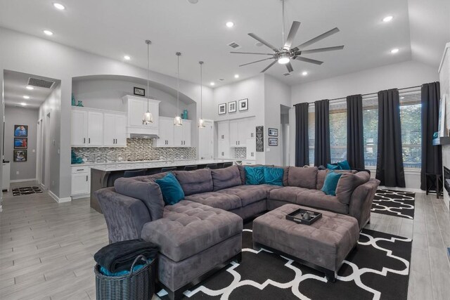 living room featuring ceiling fan and high vaulted ceiling