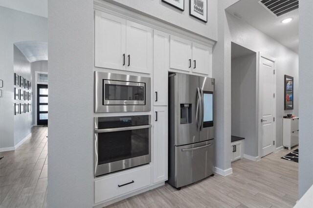 kitchen featuring stainless steel appliances, light wood-type flooring, and white cabinets