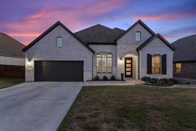 french country inspired facade with a garage and a lawn