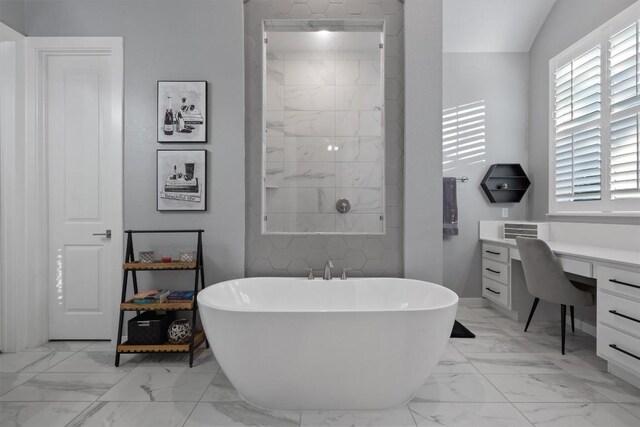 bathroom featuring vanity, lofted ceiling, a tub, and tile patterned floors