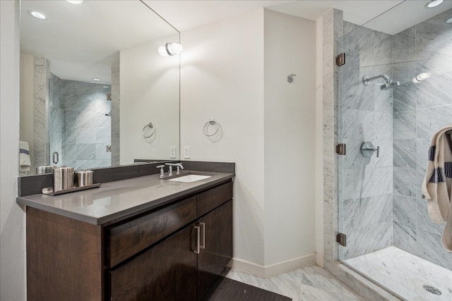 bathroom featuring a shower with shower door and vanity