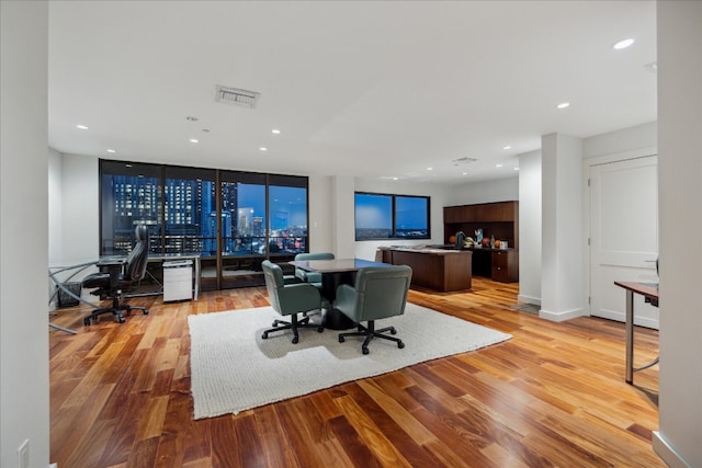 office area with light hardwood / wood-style flooring and a wall of windows