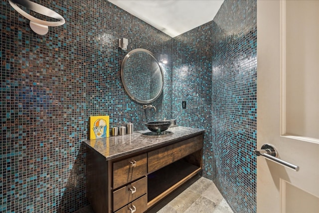 bathroom featuring vanity and tile walls