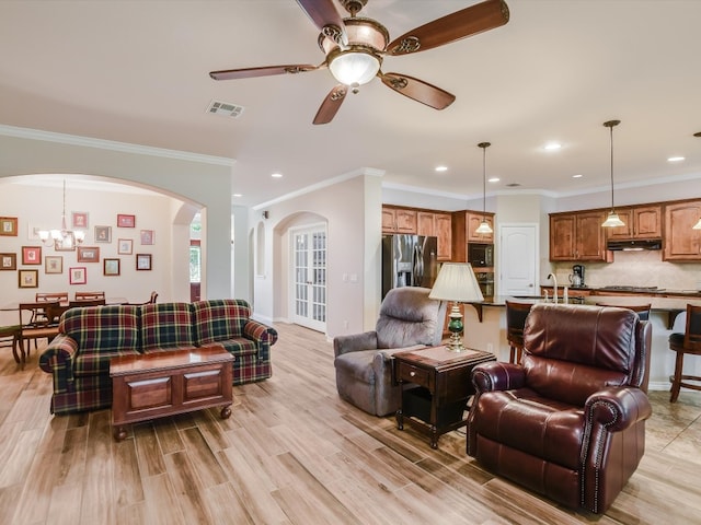 living room featuring ceiling fan with notable chandelier, crown molding, and light hardwood / wood-style floors