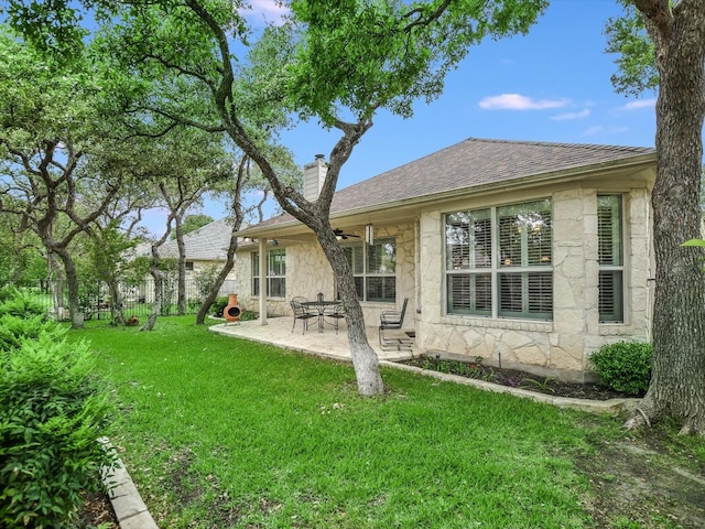 rear view of property featuring a yard and a patio area