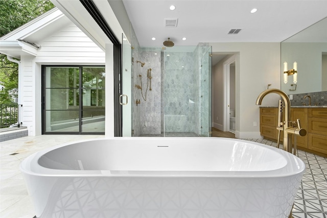 bathroom featuring a freestanding tub, a shower stall, visible vents, and recessed lighting