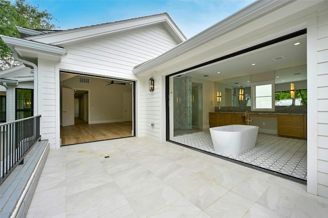 view of patio / terrace featuring a garage, driveway, and visible vents