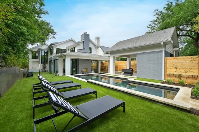 back of property featuring a yard, brick siding, a fenced backyard, and a fenced in pool