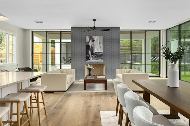 interior space with a wall of windows, light wood-type flooring, and visible vents