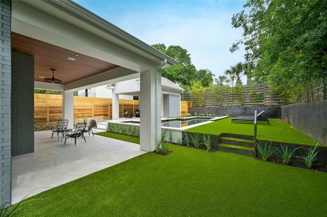 view of yard featuring ceiling fan and a patio