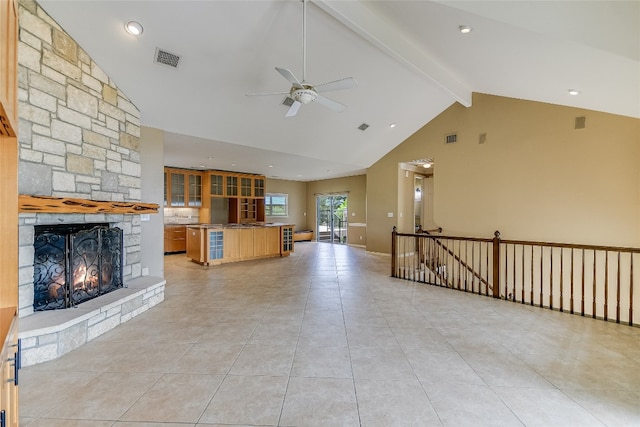 unfurnished living room featuring ceiling fan, beamed ceiling, light tile floors, and a fireplace