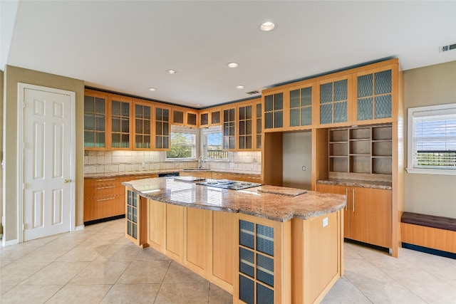 kitchen with a kitchen island, sink, backsplash, and light tile floors