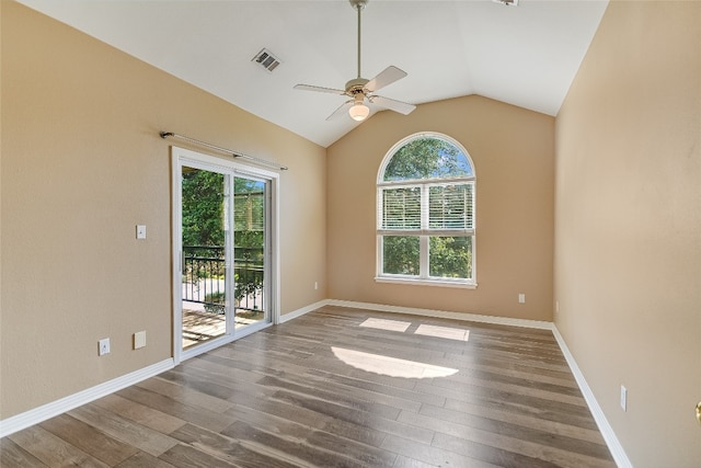 empty room featuring a healthy amount of sunlight, ceiling fan, hardwood / wood-style floors, and vaulted ceiling