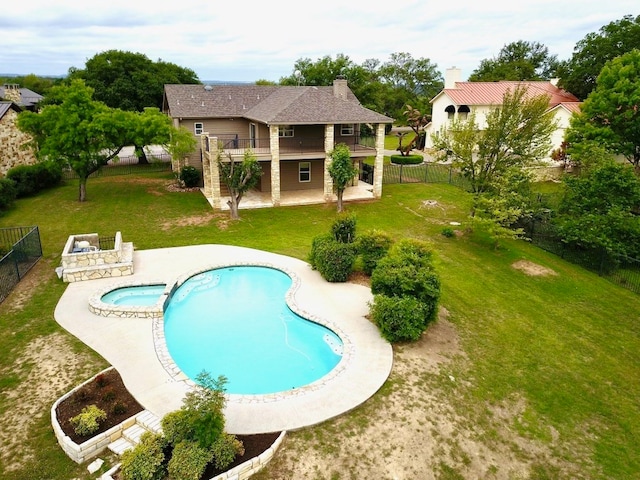 view of swimming pool featuring a patio, a lawn, and an in ground hot tub