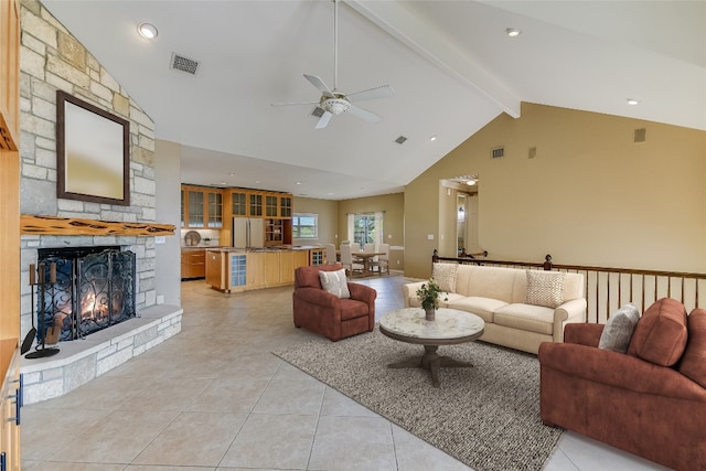 living room with beam ceiling, ceiling fan, a fireplace, and light tile floors