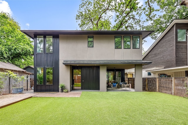 back of house with a patio and a yard