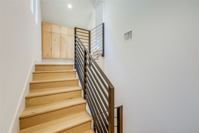 stairway featuring a towering ceiling