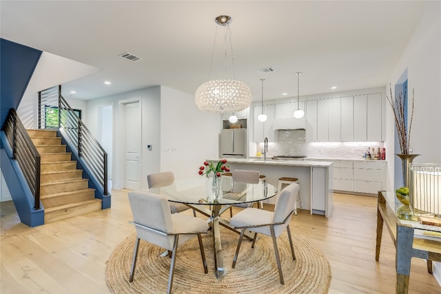 dining area featuring light hardwood / wood-style flooring and an inviting chandelier