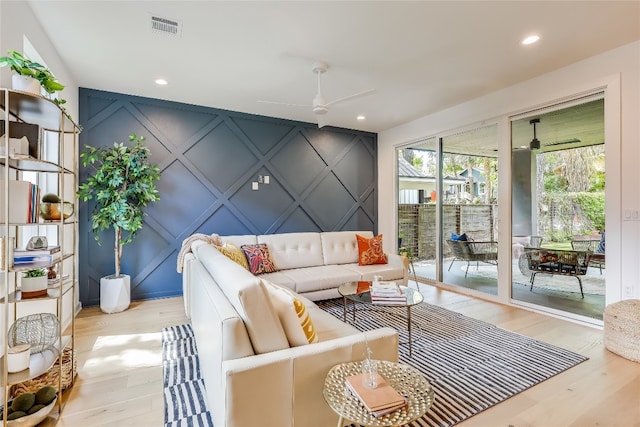 living room featuring light wood-type flooring and ceiling fan