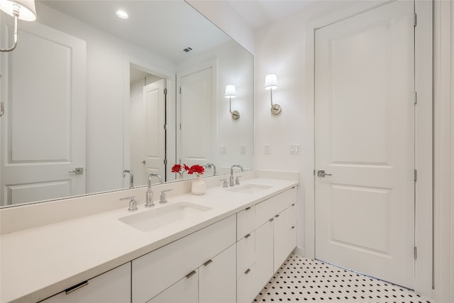 bathroom featuring vanity with extensive cabinet space, double sink, and tile floors