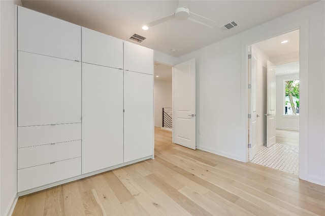 closet with ceiling fan and light wood-type flooring