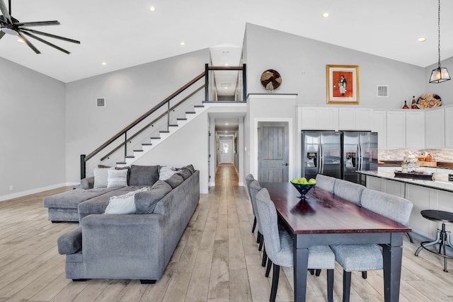 living room featuring high vaulted ceiling, light hardwood / wood-style flooring, and ceiling fan