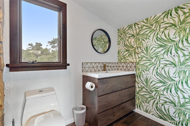 bathroom with vanity, toilet, and hardwood / wood-style floors