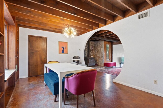 tiled dining room featuring a wood stove, beam ceiling, a chandelier, and wood ceiling