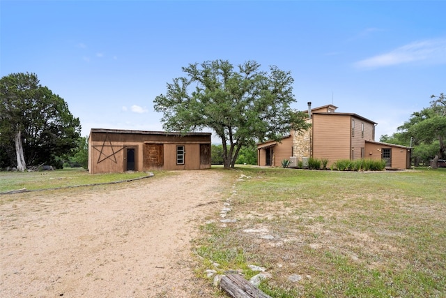 view of front facade featuring an outbuilding and a front yard