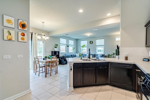 kitchen with kitchen peninsula, black appliances, sink, a notable chandelier, and light tile floors