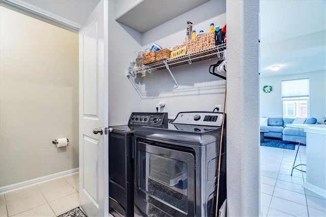 laundry area featuring washer and dryer and light tile floors