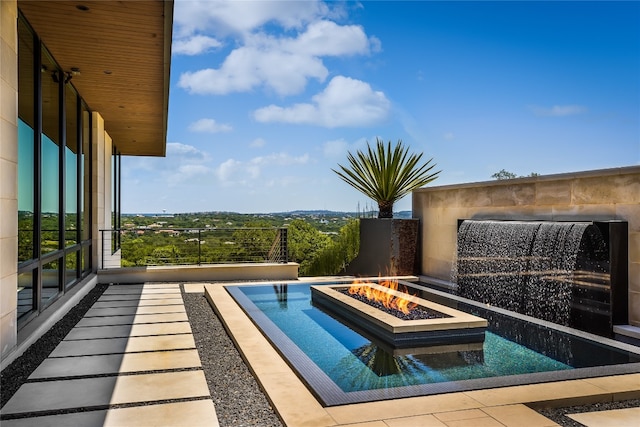 view of swimming pool with a fire pit