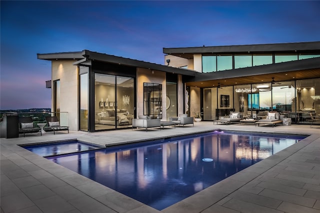 pool at dusk featuring outdoor lounge area, a patio, and ceiling fan