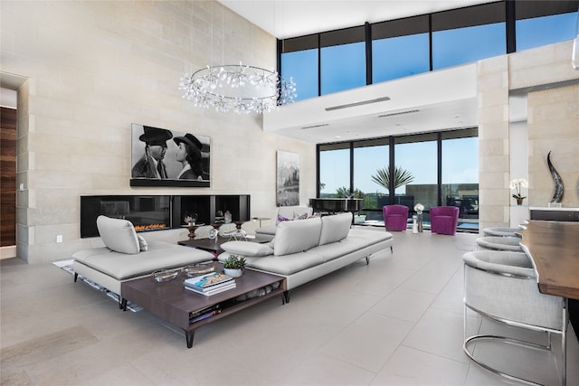 tiled living room featuring a high ceiling and a notable chandelier