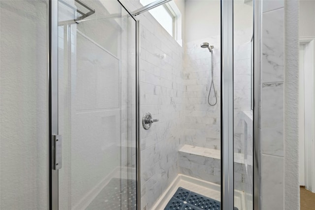 bathroom with a shower with door