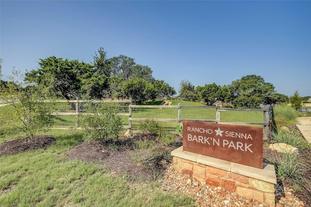 community / neighborhood sign with a rural view and a yard